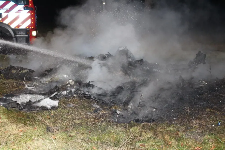 Brandweer blust rommel naast weg in Emmen