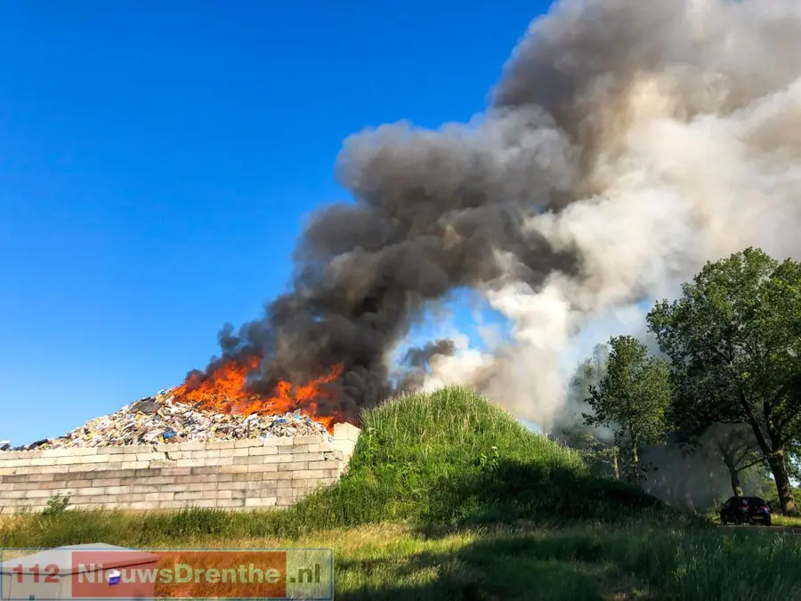 Brandweer uitgerukt voor grote brand in afvalbult op bedrijventerrein in Nieuw-Dordrecht, rookpluim is in wijde omgeving te zien
