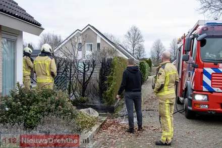 Brandweer blust brand in coniferenhaag in Emmen — foto 2 van 4