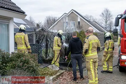 Brandweer blust brand in coniferenhaag in Emmen — foto 3 van 4