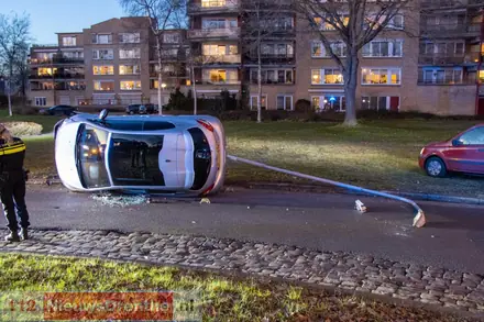 Auto ramt lantaarnpaal en belandt op zijkant in Emmen — foto 3 van 4