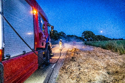 Brandweer blust broei in stro langs weg in Nijeveen — foto 2 van 4