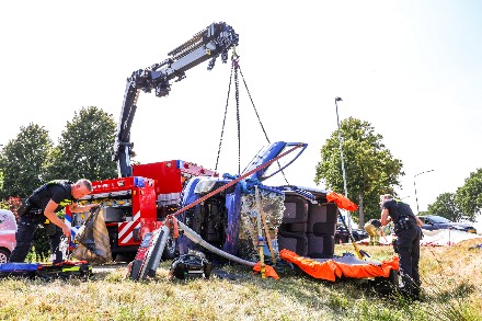 Auto belandt op zijkant na botsing tegen lantaarnpaal; bestuurder bekneld — foto 6 van 6
