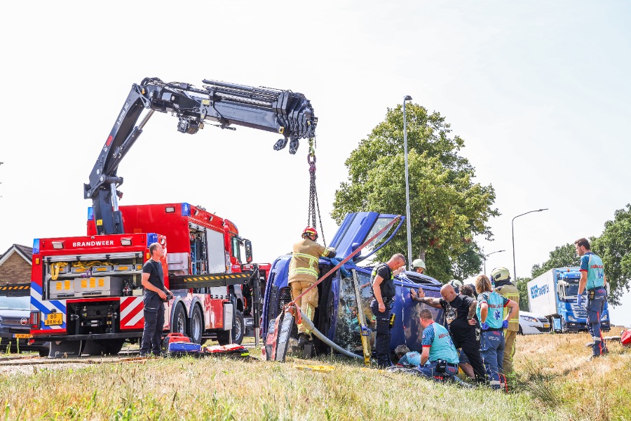 Auto belandt op zijkant na botsing tegen lantaarnpaal; bestuurder bekneld — Emmer-Compascuum